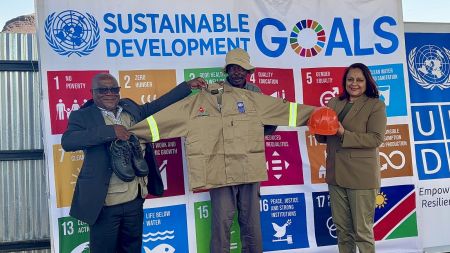 XOBOXOBOS, 27 July 2024 - United Nations Development Program Resident Representative in Namibia Alka Bhatia with Deputy Executive Director in the Mines Ministry Erasmus Shivolo handing over personal protective equipment to one of the small scale miners who mine semi-precious stones at Xoboxobos in the Uis Area in Erongo Region. (Photo by: Isabel Bento) NAMPA