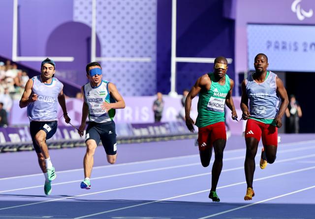 PARIS, 04 September 2024 – Namibian sprinters Ananias Shikongo and his guide Even Tjiuiju, and Urganchbek Egamnazarov and his guide Sardorwhile Bakhtiyorov (left) in action during the heats of the men’s T11 100-meter race at the Stade de France. (Photo by: Hesron Kapanga) NAMPA