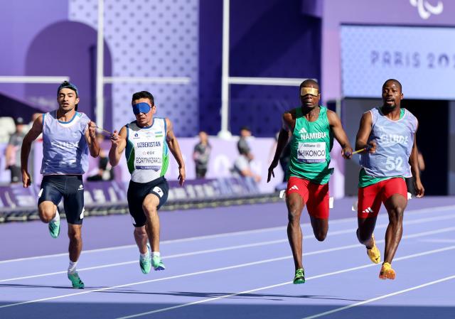 PARIS, 04 September 2024 – Namibian sprinters Ananias Shikongo and his guide Even Tjiuiju, and Urganchbek Egamnazarov and his guide Sardorwhile Bakhtiyorov (left) in action during the heats of the men’s T11 100-meter race at the Stade de France during the Paris 2024 Paralympic Games. (Photo by: Hesron Kapanga) NAMPA