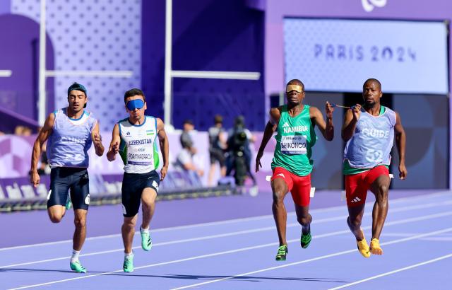 PARIS, 04 September 2024 – Namibian sprinters Ananias Shikongo and his guide Even Tjiuiju, and Urganchbek Egamnazarov and his guide Sardorwhile Bakhtiyorov (left) in action during the heats of the men’s T11 100-meter race at the Stade de France during the Paris 2024 Paralympic Games. (Photo by: Hesron Kapanga) NAMPA