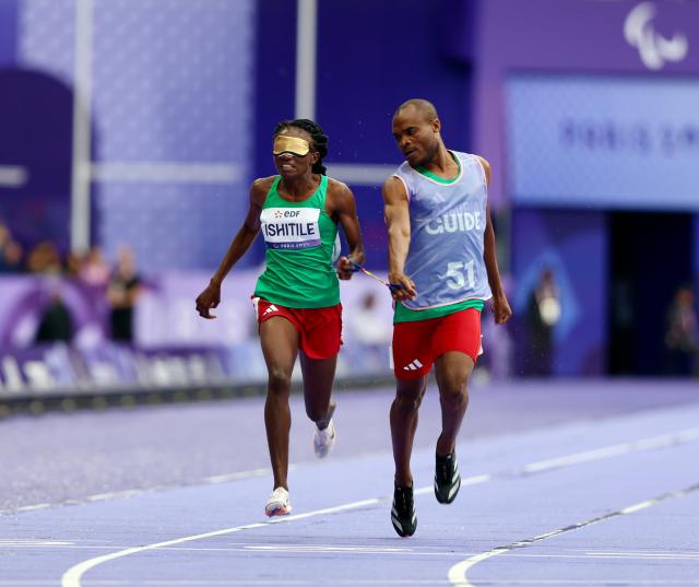 PARIS, 05 September 2024 – Namibian sprinter Lahja Ishitile and her guide Sem Shimanda in action during the semi-final heats of the women’s T11 200-meter race at a rainy Stade de France during the Paris 2024 Paralympic Games. (Photo by: Hesron Kapanga) NAMPA