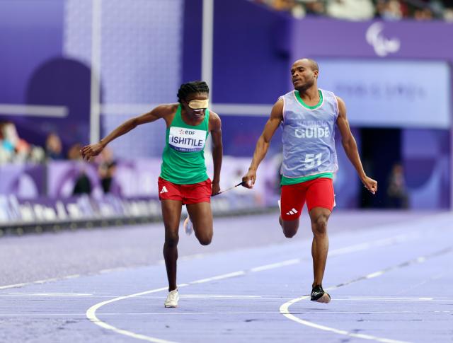 PARIS, 05 September 2024 – Namibian sprinter Lahja Ishitile and her guide Sem Shimanda in action during the semi-final heats of the women’s T11 200-meter race at a rainy Stade de France during the Paris 2024 Paralympic Games. (Photo by: Hesron Kapanga) NAMPA