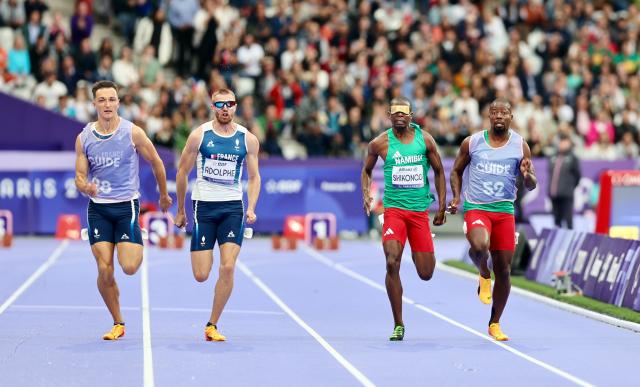 PARIS, 05 September 2024 – Namibia’s 2016 Paralympic Games gold medalist Ananias Shikongo and his guide Even Tjiuiju and French sprinter Timothee Adolphe and his guide Charles Renard (left) in action during the final of the men’s T11 100-meter race at the Stade de France during the Paris 2024 Paralympic Games. (Photo by: Hesron Kapanga) NAMPA