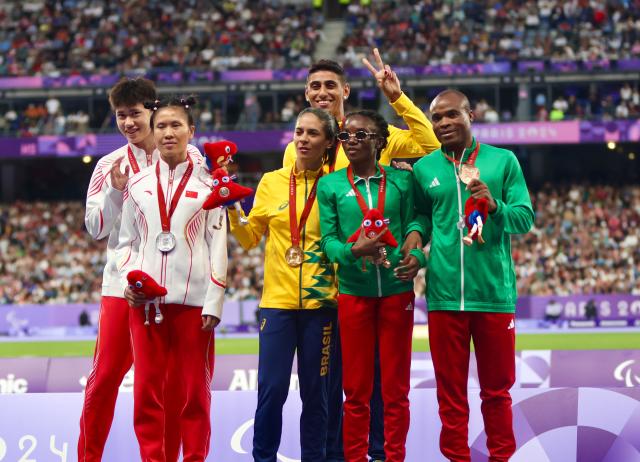 PARIS, 07 September 2024 – Paralympic sprinter Lahja Ishitile and her guide Sem Shimanda, Brazilian sprinter Jerusa Geber dos Santos and guide Gabriel Garcia dos Santos (centre) and Cuiqing Liu and guide Shengming Chen (left) during the medal ceremoy of the women’s T11 200 metre (m) race at the Stade de Paris. (Photo by: Hesron Kapanga) NAMPA