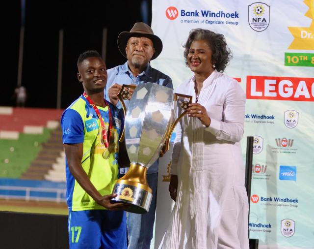 WINDHOEK, 19 September 2024 - Eeshoke Chula - Chula captain Haidula Fares posing for a photo with the former first lady Monica Geingos (in white) and President Nangolo Mbumba during the trophy handing over ceremony of the Dr Hage Geingob Cup Cup at the Independence Stadium. (Photo by: Hesron Kapanga) NAMPA