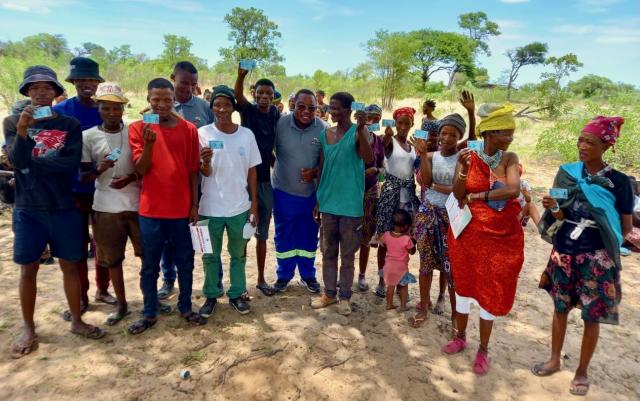 ||Nhoma, 20 November 2024 - A group of San people from the Ju|'Hoansi clan living in ||Nhoma poses for a picture with a member of the Electoral Commission of Namibia and their voters cards ahead of Namibia’s 2024 Presidential and National Assembly elections. (Photo: contributed) NAMPA