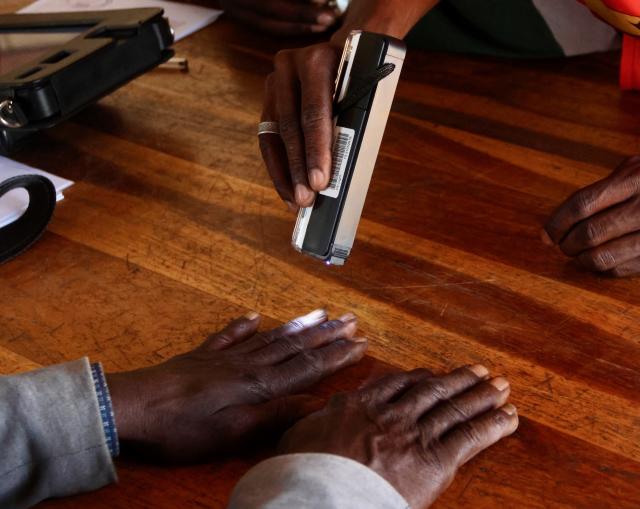 GAM, 27 November 2024 – The Polling  Officer screening the fingers of an elderly voter at the Gam Polling Station in the Tsumkwe Constituency, during the 2024 Presidential and National Assembly Elections. (Photo b: Hesron Kapanga) NAMPA