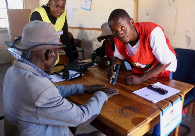 GAM, 27 November 2024 – The Polling  Officer screening the fingers of an elderly voter at the Gam Polling Station in the Tsumkwe Constituency, during the 2024 Presidential and National Assembly Elections. (Photo b: Hesron Kapanga) NAMPA