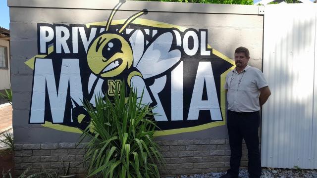 OUTJO, 31 JANUARY 2025 - Principal of Moria Private School, Loutjie Grobler Standing in front of the schools mural. (Photo by: Dalene Kooper) NAMPA