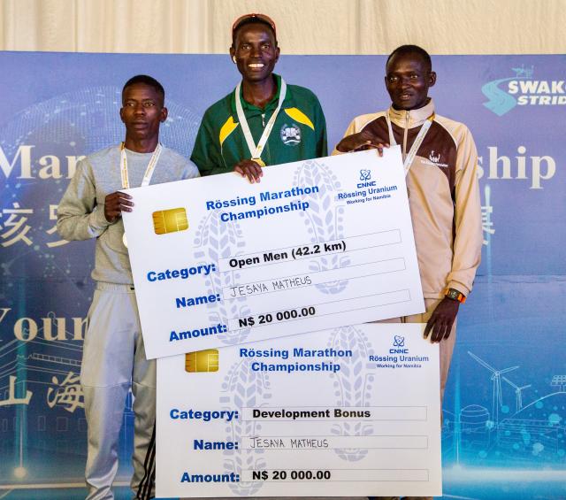 WINDHOEK, 08 March 2025 - Namibia Correctional Service runners Jesaya Matheus (centre) andTangeni Sakaria (left) and Enock Haufiku (right) pose for a picture during the award ceremony the 34th Rössing National Marathon champions in Swakopmund the championship, featured over 3,000  runners. (Photo contributed) NAMPA