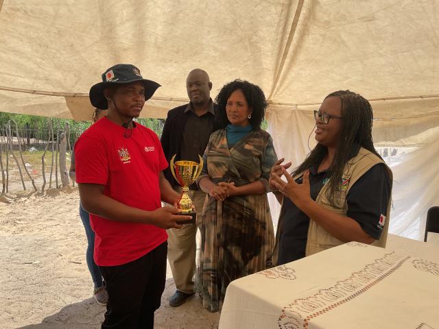 RUNDU, 11 March 2025 - Small-scale horticulture producer in the Kavango West Region Michael Kambinda receives a trophy on behalf of Kombara Youth Garden as the best Small-scale horticulture producers of 2024. (Photo by: Sawi Hausiku) NAMPA 