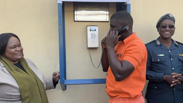 WALVIS BAY, 06 JUNE 2025 - Minister of Home Affairs, Immigration, Safety and Security Lucia Iipumbu and Commissioner General of the Namibia Correctional Service Raphael Hamunyela watch on as an inmate in the Walvis Bay Correctional Facility uses the telio inmate telephone system which was officially launched at the facility on Friday. (Photo by: Isabel Bento) NAMPA