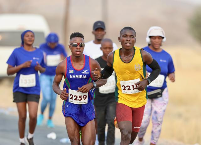 KARIBIB, 20 Sepetember 2025 - Long-distance runners representing the Namibian Police Force (NamPol) and Namibia Correctional Service, Matias Simon (in blue) and Simon Paulus (in yellow) while in action during the 11th edition of the QKR Namibia Navachab half-marathon in Karibib. (Photo by: Hesron Kapanga) NAMPA

