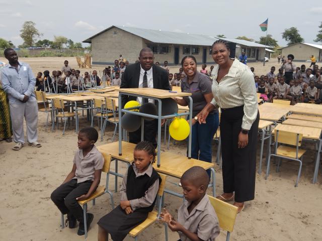 KATIMA MULILO, 05 November 2025 - Alufea Sampofu Combined School in the Zambezi Region on Wednesday officially received a pledge of 100 new chairs and 100 new desks made possible by Greatlands Investments. In this photo Acting Regional Director for Education, Norah Munembo (right) gestures after the official ceremony. She is flanked by school principal Moses Kalonda and Greatlands Investment Human Resources Director, Fredrika Nambahu as well as some learners at the school.

 
(Photo: Michael Mutonga Liswaniso) NAMPA
