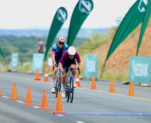 WINDHOEK, 08 February 2026 - Junior rider Roger Suren (in meroon) while in action against Alex Miller during the 2026 Nedbank Namibia National Road Race champions. Suren was crowned national champion for 2026 in the road race after completing the 167 kilometres race  that saw them ride through the new A1 and Dordabis road. (Photo by: Hesron Kapanga) NAMPA
