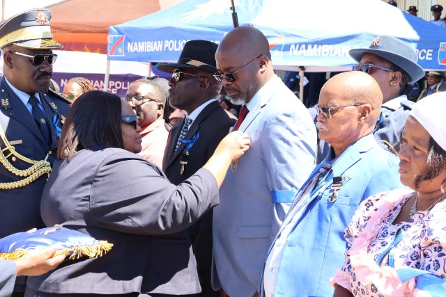 WINDHOEK, 07 March 2026 - Sankwasa Mubita receiving the medal of honour from Home Affairs, Immigration, Safety and Security Minister Lucia Iipumbu  in memory of his late cousin, Sergeant Eustece Simasiku Matengu
