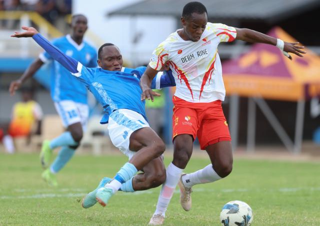 WINDHOEK, 14 March 2026 - UNAM FC defender, Josef Bonifasius (white and red) while in action against KK Palace players Vickson Shivute (left) at the UNAM Stadium during round 25 of the Namibia Premier Football League. The match ended 2-1 in favour of UNAM. (Photo by: Hesron Kapanga) NAMPA