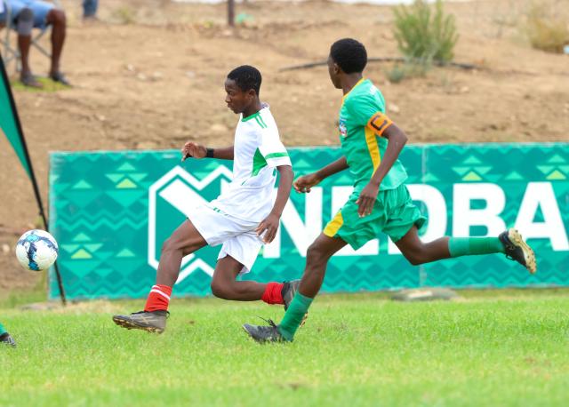 KEETMANSHOOP, 03 April 2026 - Action between a Kavango East player and(in white) and an Omaheke player in (green) during the 24th edition of the Nedbank Namibian Newspaper Cup at the West dene Stadium in Keetmanshoop. The opening match between the two sides in Group A, ended 1-1. (Photo by: Hesron Kapanga) NAMPA 