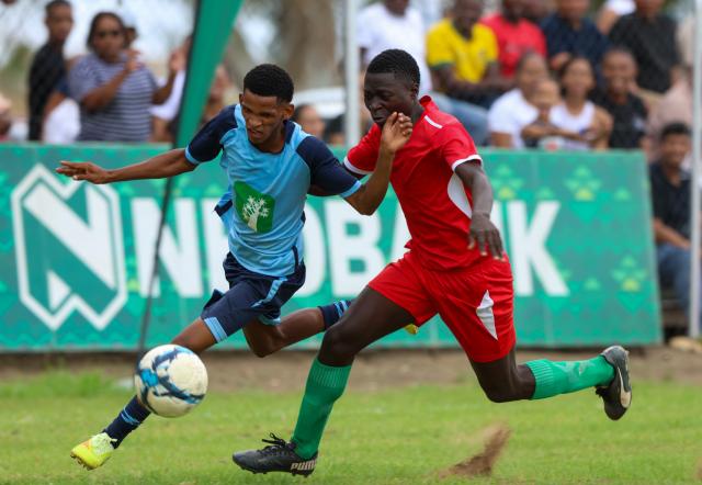 KEETMANSHOOP, 03 April 2026 - Action between Kavango West player Gideon Kayundu (in red) and ||Kharas player Johan Kooper during the 24th edition of the Nedbank Namibian Newspaper Cup at the Westdene Stadium in Keetmanshoop. The opening match between the two sides in Group B, ended 2-1 in favour of ||Kharas. (Photo by: Hesron Kapanga) NAMPA