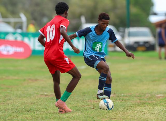 KEETMANSHOOP, 03 April 2026 - Action between Kavango West player Fredy Kupembona (in red) and a ||Kharas player (in light blue) during the 24th edition of the Nedbank Namibian Newspaper Cup at the Westdene Stadium in Keetmanshoop. The opening match between the two sides in Group B, ended 2-1 in favour of ||Kharas. (Photo by: Hesron Kapanga) NAMPA