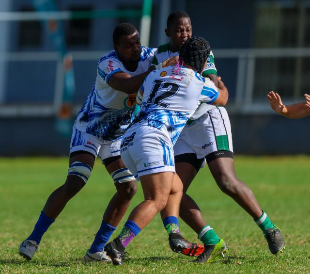 WINDHOEK, 18 April 2026 - A Western Suburbs player (in green and white) takes on Grootfontein opponents (in blue and white) during their Round Two clash of the Namibia Rugby Union Premier League at Suburbs Park in Khomasdal. (Photo by: Hesron Kapanga) NAMPA