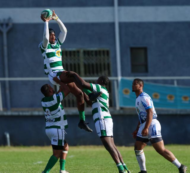 WINDHOEK, 18 April 2026 - A Western Suburbs player (in green and white) takes on Grootfontein opponents (in blue and white) during their Round Two clash of the Namibia Rugby Union Premier League at Suburbs Park in Khomasdal. (Photo by: Hesron Kapanga) NAMPA