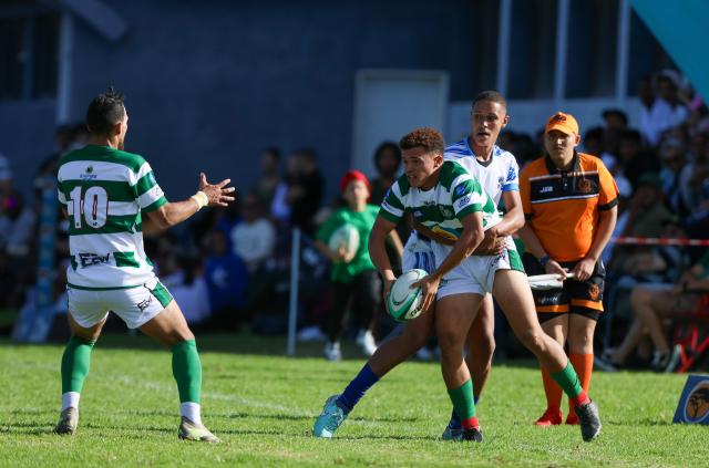 WINDHOEK, 18 April 2026 - A Western Suburbs player (in green and white) takes on Grootfontein opponents (in blue and white) during their Round Two clash of the Namibia Rugby Union Premier League at Suburbs Park in Khomasdal. (Photo by: Hesron Kapanga) NAMPA
