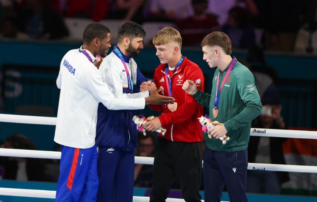 GLASGOW, 01 August  2026 – Namibia’s boxer Tryagain Morning Ndevelo celebrating with other boxers from left Sachin Sachin of India, Owain Harris-Allan of Wales, and Northern Ireland's Jude Gallagherhis during the medal award ceremony of the 60kg at the Commonwealth Games in Glasgow, Scotland. (Photo: Hesron Kapanga) NAMPA