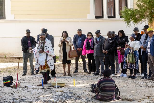CAPE TOWN, 12 August 2026 – A Namibian traditional practitioner performs a spiritual cleansing ritual alongside members of the Namibian delegation in Cape Town. Cultural rites form a pivotal part of the exhumation process to honour the spirits of fallen liberation heroes Simon Petrus Niilenge, Festus Nehale, and their comrades before their repatriation back home. (Photo Contributed: MICT) NAMPA