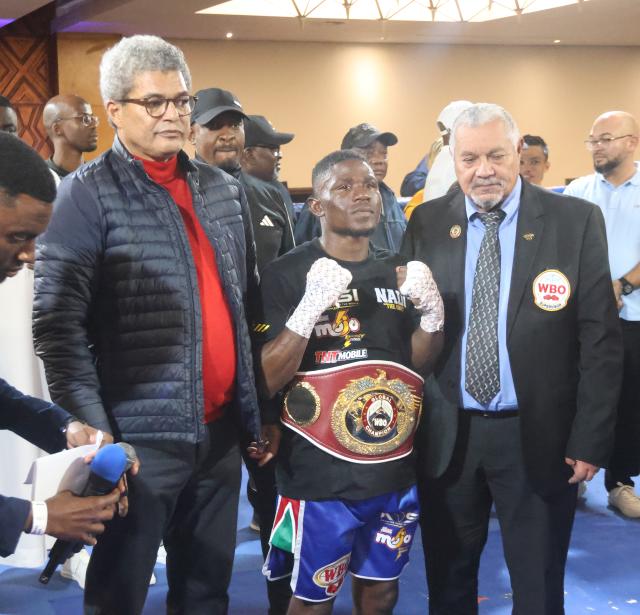 WINDHOEK, 20 September 2026 – Namibia’s World Boxing Organisation (WBO) Global flyweight champion Fillemon Nghutenanye (centre) alongside WBO official and the Namibia Control Board Chairperson defeating Berland Robles of the Philippines at the Windhoek Country Club and Resort during the Salute Boxing Promotions’ Building of Champions: Battle for Greatness Boxing Bonanza. Nghutenanye securing a fifth-round technical knockout victory. (Photo: Hesron Kapanga) NAMPA
