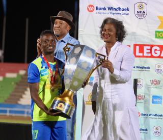 WINDHOEK, 19 September 2024 - Eeshoke Chula-Chula captain Haidula Fares pictured with former First Lady Monica Geingos (in white) and President Nangolo Mbumba during the trophy handing over ceremony of the Dr Hage Geingob Cup Cup at the Independence Stadium. (Photo by: Hesron Kapanga) NAMPA