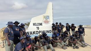 SWAKOPMUND, 14 March 2025 - The 24 ranger guards at the 'Welcome to Swakopmund' sign upon completion of the 360-kilometre walk from Windhoek to Swakopmund on Friday. The walk was aimed at raising awareness of human-elephant conflict and advocating for sustainable coexistence between communities and wildlife. (Photo by: Isabel Bento) NAMPA