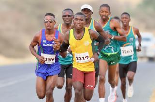 KARIBIB, 20 Sepetember 2025 - Long-distance runners representing the Namibian Police Force (NamPol) and Namibia Correctional Service, Matias Simon (in blue) and Simon Paulus (in yellow) while in action during the 11th edition of the QKR Namibia Navachab half-marathon in Karibib. (Photo by: Hesron Kapanga) NAMPA
