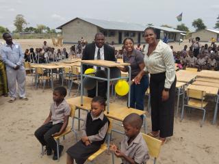 KATIMA MULILO, 05 November 2025 - Alufea Sampofu Combined School in the Zambezi Region on Wednesday officially received a pledge of 100 new chairs and 100 new desks made possible by Greatlands Investments. In this photo Acting Regional Director for Education, Norah Munembo (right) gestures after the official ceremony. She is flanked by school principal Moses Kalonda and Greatlands Investment Human Resources Director, Fredrika Nambahu as well as some learners at the school.

 
(Photo: Michael Mutonga Liswaniso) NAMPA

