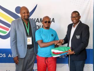 WINDHOEK, 11 November 2025 - (From left) Namibia Sports Commission Chief Administrator Freddy Mwiya; Namibia Deaf Sport Federation (NDSF) president, Abner Shaya, and Commissioner Linekela Paul Nanyeni during the handing over of national colours to the NDSF president ahead of their trip to Japan to compete in their maiden Deaflympics. (Photo by: Hesron Kapanga) NAMPA