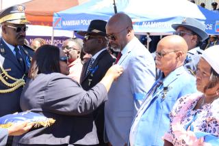 WINDHOEK, 07 March 2026 - Sankwasa Mubita receiving the medal of honour from Home Affairs, Immigration, Safety and Security Minister Lucia Iipumbu  in memory of his late cousin, Sergeant Eustece Simasiku Matengu
