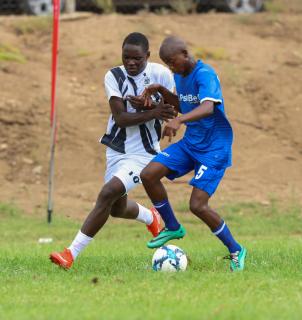 KEETMANSHOP, 03 March 2026 - Festus Natangwe of Oshikoto (in black and white) while in action against Likius Shikongo (in blue) of Ohangwena during their opening match of the 2026 Nedbank Namibian Newspaper Cup at the Westdene Stadium in Keetmanshoop. The match ended 4-1 in favour of Ohikoto. (Photo by: Hesron Kapanga) NAMPA