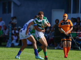 WINDHOEK, 18 April 2026 - A Western Suburbs player (in green and white) takes on Grootfontein opponents (in blue and white) during their Round Two clash of the Namibia Rugby Union Premier League at Suburbs Park in Khomasdal. (Photo by: Hesron Kapanga) NAMPA
