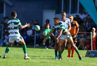 WINDHOEK, 18 April 2026 - A Western Suburbs player (in green and white) takes on Grootfontein opponents (in blue and white) during their Round Two clash of the Namibia Rugby Union Premier League at Suburbs Park in Khomasdal. (Photo by: Hesron Kapanga) NAMPA