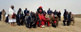 SWAKOPMUND, 28 May 2026 - Chiefs of the Zeraeua and !Oe-ǂGan Traditional Authorities Ombara Manase Christian Zeraeua and Gaob Immanuel ǂNu-axa ǃGâseb (l), Chairperson of the Genocide Committee in Erongo Uahimisa Kaapehi (m) and other political and traditional leaders kneel at the entrance of the Swakopmund Memorial Park to seek for permission from the ancestors before entering the cemetery, during the Ovaherero and Nama Genocide. (Photo by: Isabel Bento) NAMPA
