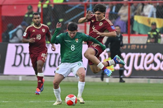 Bolivia's defender Luis Paz (C) and Venezuela's defender Jon Aramburu (R) fight for the ball during the 2026 FIFA World Cup South American qualifiers football match between Bolivia and Venezuela, at the Municipal stadium, in El Alto, Bolivia, on September 5, 2024. (Photo by AIZAR RALDES / AFP)