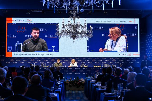 A screen displays a live footage of Ukraine's President, Volodymyr Zelensky (L) as he delivers a speech on the opening day of the 50th edition of The European House-Ambrossetti forum, called "Intelligence on the World, Europe, and Italy" at Villa d'Este on lake Como in Cernobbio, northern Italy, on September 6, 2024. The annual three-day event brings together senior figures in business and industry from both Italy and abroad, alongside diplomats and members of government. (Photo by Piero CRUCIATTI / AFP)