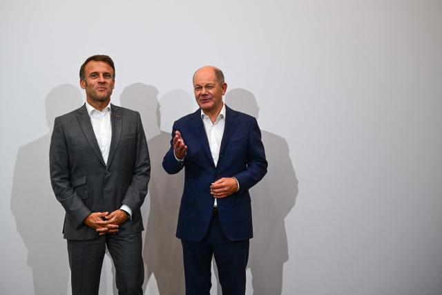 France's President Emmanuel Macron (L) and Germany's Chancellor Olaf Scholz share a light moment as they meet during the 33rd Evian Annual Meeting to promote economic cooperation at Evian in the French Alps on September 6, 2024. (Photo by OLIVIER CHASSIGNOLE / POOL / AFP)