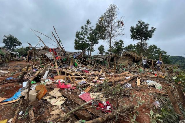 People stand next to destroyed shelters at a camp for internally displaced people following an air strike near Pekon township in Myanmar's south Shan state on September 6, 2024. (Photo by AFP)