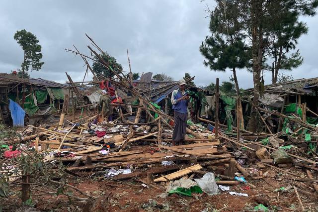 A man stands next to destroyed shelters at a camp for internally displaced people following an air strike near Pekon township in Myanmar's south Shan state on September 6, 2024. (Photo by AFP)