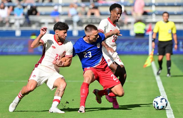 Canada's midfielder Jonathan Osorio (Lt) and Canada's midfielder Ali Ahmed (R) double-team United States' defender Kristoffer Lund in the second half of an international friendly football match between USA and Canada at Children's Mercy Park in Kansas City, Kansas, on September 7, 2024. (Photo by Tim Vizer / AFP)