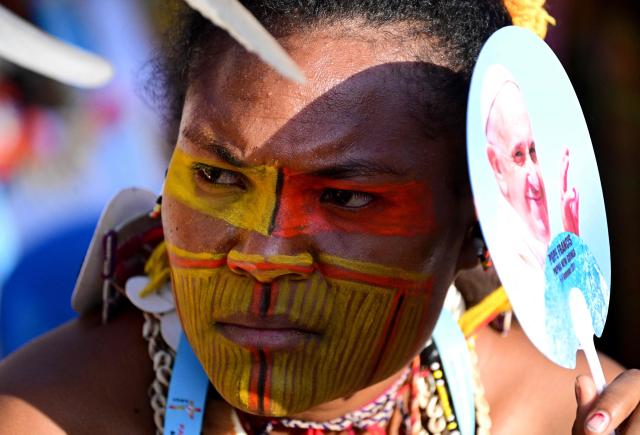 A person holds a fan with a portrait of Pope Francis as they attend holy mass at Sir John Guise Stadium in Port Moresby, Papua New Guinea, on September 8, 2024. Pope Francis is leading holy mass at the Sir Guise Stadium during his four day visit to Papua New Guinea from September 6-9. (Photo by Tiziana FABI / AFP)