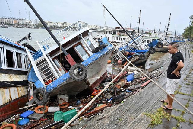 A man checks boats damaged after Super Typhoon Yagi hit Ha Long bay, in Quang Ninh province, on September 8, 2024. Super Typhoon Yagi uproots thousands of trees, sweeps ships and boats out to sea and rips roofs off houses in northern Vietnam, after leaving a trail of destruction in southern China and the Philippines. (Photo by Nhac NGUYEN / AFP)