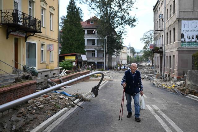 An elderly man walks among debris in a street following the floods in Ladek-Zdroj, southern Poland, on September 18, 2024. The toll from storms in central and eastern Europe rose to at least 24 people on September 18, 2024, as the Czech Republic reported its fourth and fifth victims. (Photo by Sergei GAPON / AFP)