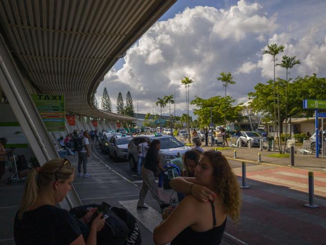 A general view shows people outside the airport at Fort-de-France in Martinique on September 20, 2024. Officials in the French Caribbean island of Martinique say on September 17, 2024 at least six police officers have been injured by gunfire during violent protests over the high cost of living. Martinique has seen similar protests in recent years, many of them fueled by anger over what demonstrators say is economic, social and racial inequality. (Photo by Ed JONES / AFP)